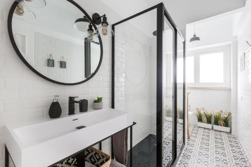 a bathroom with a white sink and a mirror at Stroll to Coffee Shops Near a Renovated Hillside Apartment in Graça in Lisbon
