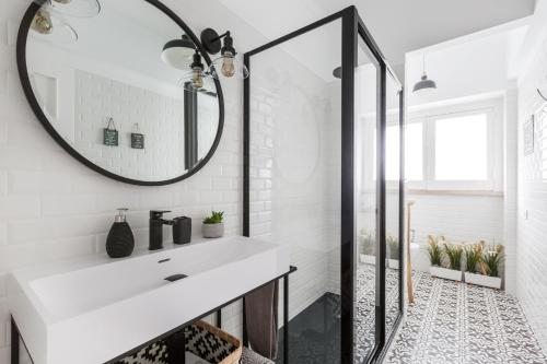 a bathroom with a white sink and a mirror at Panoramic River View 1-BR near Senhora do Monte by NestAtLisbon in Lisbon