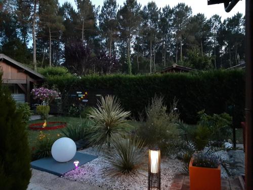 a garden with a white balloon and plants at Gite climatisé L'Orée des Landes Proche Center Parcs in Pindères