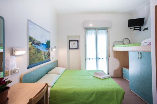 a bedroom with a green bed and a window at HOTEL SILVANA in Cattolica