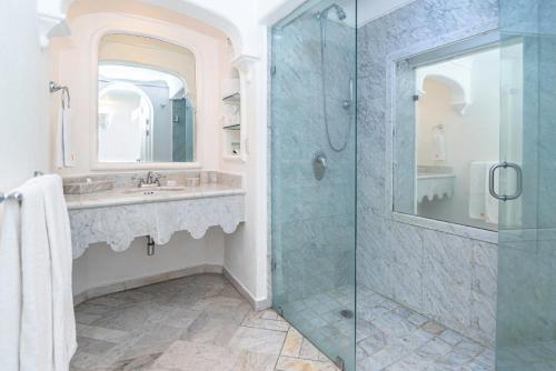 y baño con ducha acristalada y lavamanos. en Las Hadas by Brisas, en Manzanillo