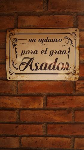 a sign on the side of a brick wall at Lujan De Cuyo B&B in Ciudad Lujan de Cuyo