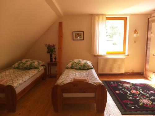 a attic room with two beds and a window at Salamandra in Krempna