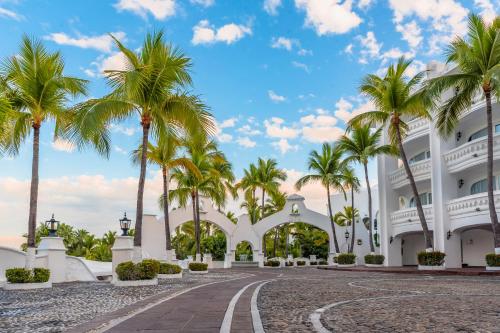 a building with palm trees in front of it at Las Hadas by Brisas in Manzanillo
