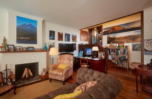 a living room with a couch and a fireplace at Casadacidade in Ponta Delgada