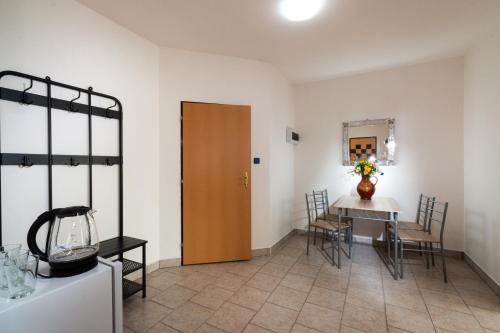 a dining room with a table and a wooden door at Penzion Kozí farma Nový Dvůr in Česká Lípa