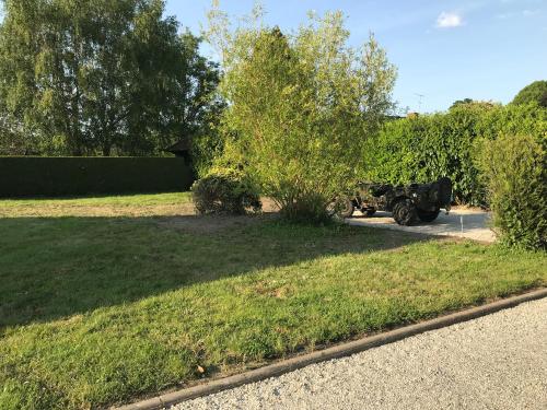 an old truck parked in a grassy yard at La ferme aux Perdrix in Beuvron-en-Auge