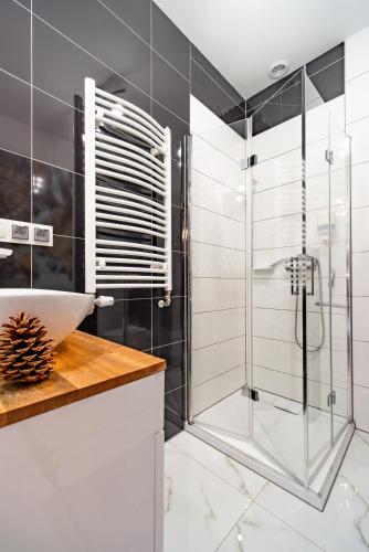 a bathroom with a glass shower and a sink at Domek pod Tatrami Jurgów noclegi in Jurgów