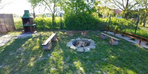 a park with a fire pit and benches in the grass at Apartamenty przy Jeziorze Żywieckim z widokiem na Skrzyczne in Żywiec
