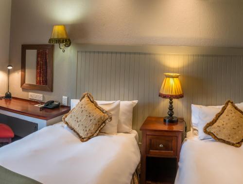 伯利恆的住宿－邊疆皮爾蒙特米特庫爾特酒店，伯利恆，一间卧室配有两张床、一张桌子和一盏灯。