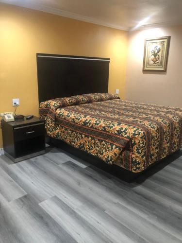 a hotel room with a bed and a night stand at Economy Inn - Ontario Airport in Ontario