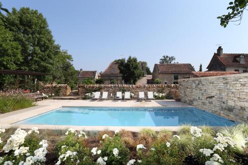 a swimming pool in the yard of a house at La Maison Du Meunier in Loze