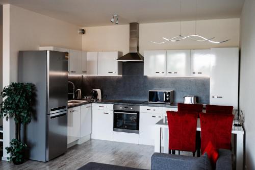 uma cozinha com armários brancos e um frigorífico de aço inoxidável em AH Radnica em Košice