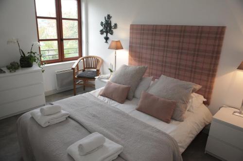 a bedroom with a large bed with towels on it at B&B Le Fond de la Cour in Honfleur