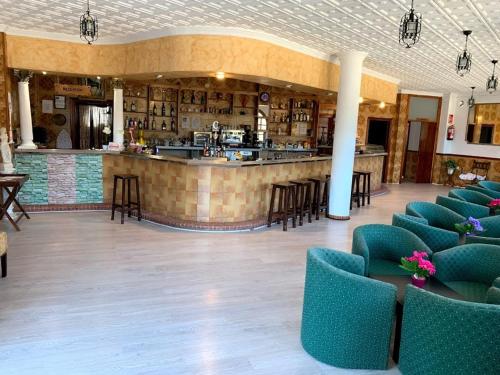 a lobby with a bar with chairs and a counter at Hostal Los Arcos in Vejer de la Frontera