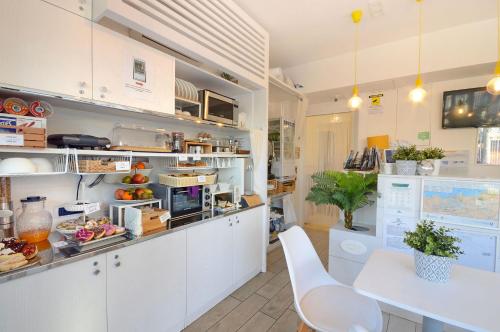 a kitchen with white cabinets and a table and chairs at B&B Sorrento Central in Sorrento