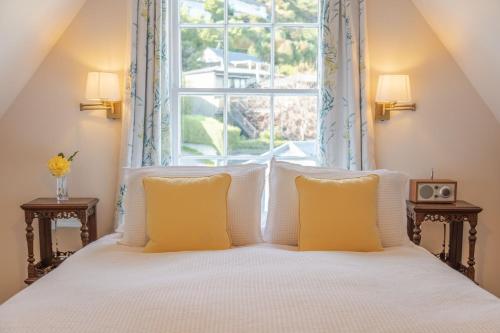 a bedroom with a white bed with a window at French Bay House in Akaroa