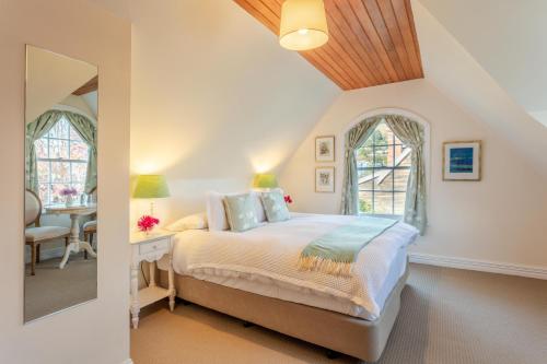 a bedroom with a bed and a table in a room at French Bay House in Akaroa