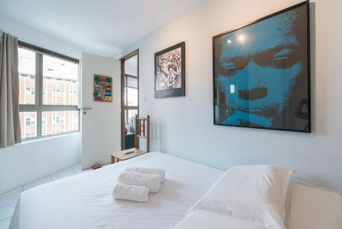 1 dormitorio con 1 cama blanca y una gran pintura en la pared en Ótimo Flat Bairro da Jaqueira Recife até 3 pessoas O Coração Verde da Cidade PBO902, en Recife