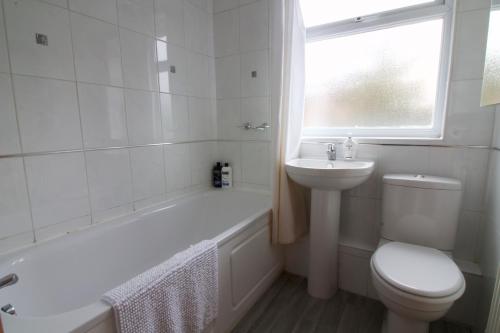 a white bathroom with a toilet and a sink at Somers House - pet friendly & parking in Portsmouth