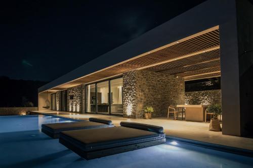 a villa with a swimming pool at night at Nuez Villas in Mochlos