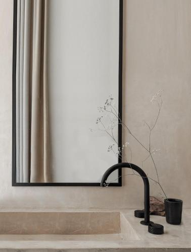 a bathroom sink with a faucet in front of a mirror at Nuez Villas in Mochlos