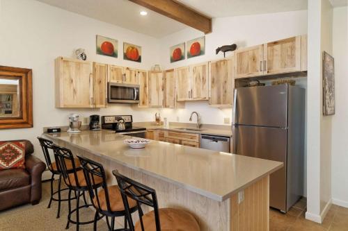 a kitchen with wooden cabinets and a stainless steel refrigerator at Shadowbrook 303 in Snowmass Village