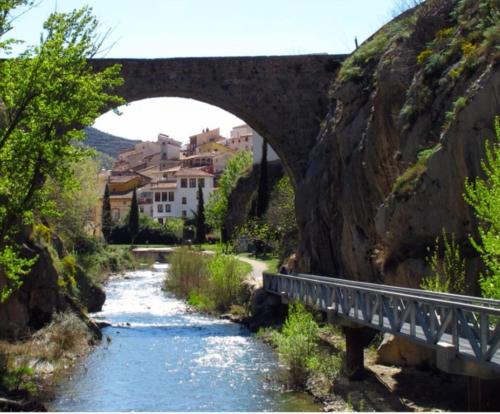 a bridge over a river with a road under it at Apartamento Las Huellas in Arnedillo