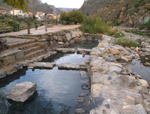 a person is standing in a pool of water at Apartamento Las Huellas in Arnedillo