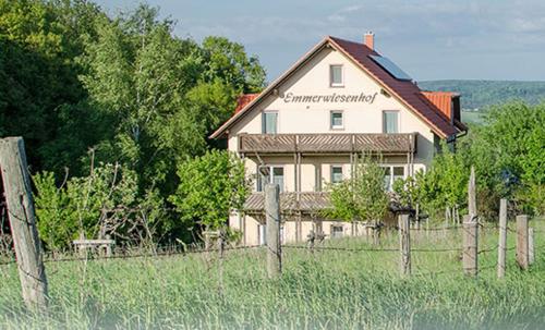 a large house in a field with a fence at Panorama Gasthof Stemler in Eulenbis