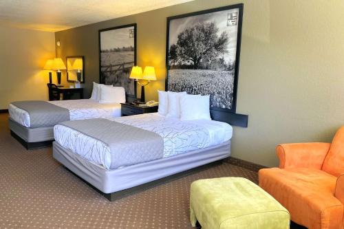 SureStay Hotel by Best Western New Braunfels في نيو بروانفيلز: غرفة فندقية بسريرين وكرسي