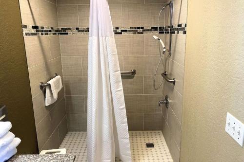 a shower with a shower curtain in a bathroom at SureStay Hotel by Best Western New Braunfels in New Braunfels