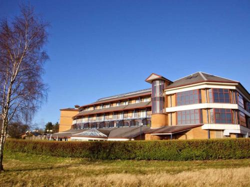 ein großes Gebäude mit einem Baum davor in der Unterkunft Derby Mickleover Hotel, BW Signature Collection in Derby