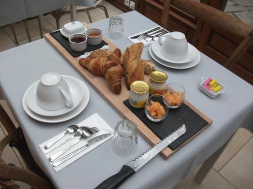 a table with a tray of croissants and other food at B&B Le Fond de la Cour in Honfleur