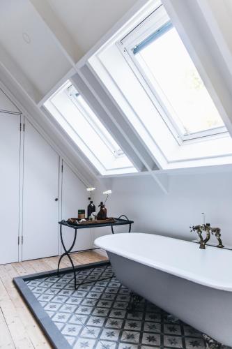 a bathroom with a large white tub and skylights at The Garden Loft at Poets Lodge in Daylesford