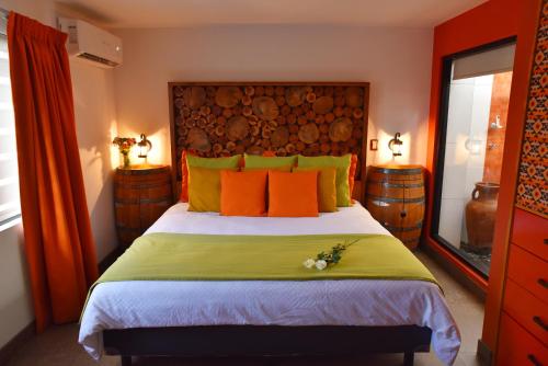 a bedroom with a bed with orange and yellow pillows at Baja Inn Hoteles Rio in Tijuana