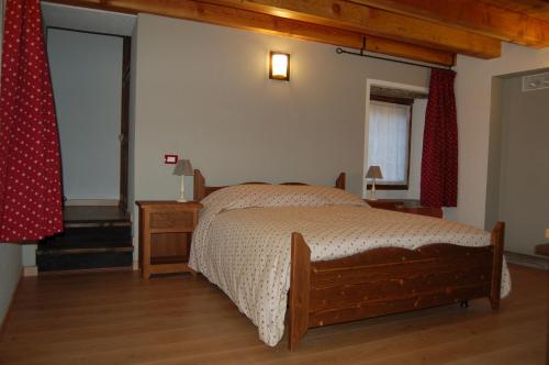 a bedroom with a bed and a wooden floor at Il Nocciolo in Bard