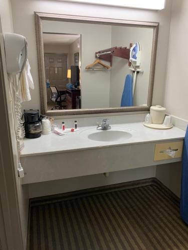 baño con lavabo y espejo grande en Days Inn by Wyndham Ocean Springs en Ocean Springs