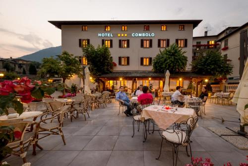 a group of people sitting at tables in front of a hotel at Hotel Ristorante Combolo in Teglio