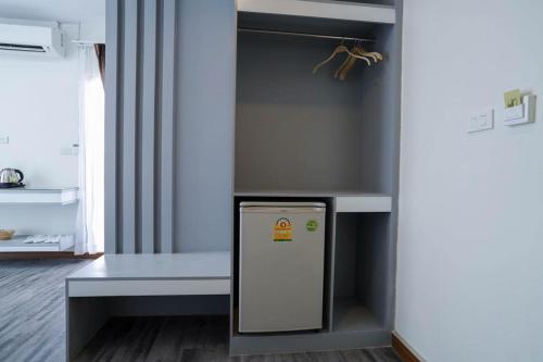 a refrigerator in a room with a shelf at Hak Heng Hotel in Krong Poi Pet