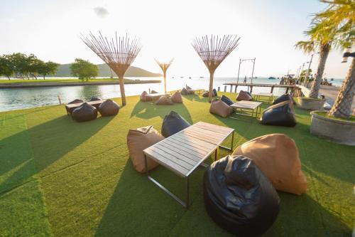 a park with benches and bean bags on the grass at Baan Tah On The Sea in Bang Sare