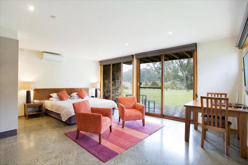 - une chambre avec un lit, un bureau et des chaises dans l'établissement Lake Crackenback Resort & Spa, à Crackenback