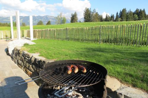 a grill with three hot dogs cooking on it at Ferienwohnung "Florin" in Ofterschwang