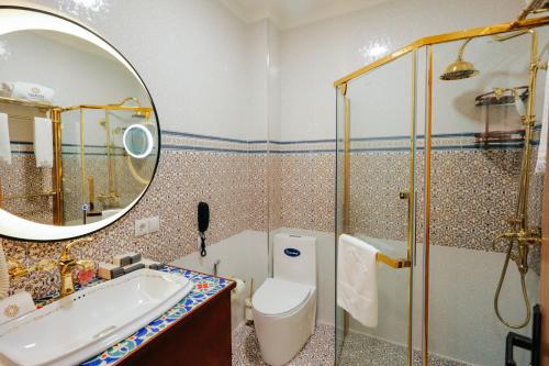 a bathroom with a sink and a toilet and a mirror at Jannat Regency Jalal-Abad in Jalal-Abad