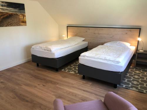 2 Einzelbetten in einem Zimmer mit einem Sofa in der Unterkunft Haus 1 in Wyk auf Föhr