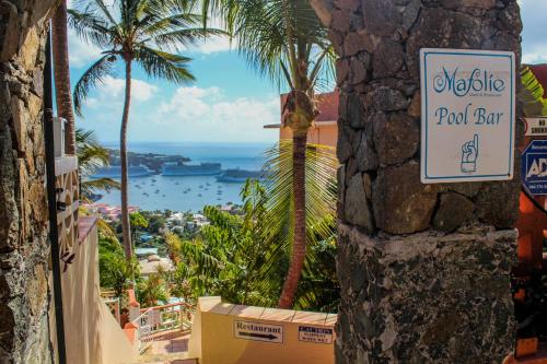 a sign for a pool bar with palm trees and the ocean at The Mafolie Hotel in Mafolie