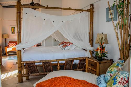 a bedroom with a four poster bed with a canopy at The Mafolie Hotel in Mafolie