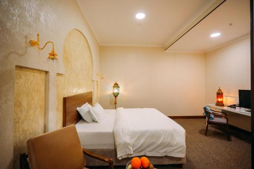 a bedroom with a bed and a desk with a computer at Jannat Regency Jalal-Abad in Jalal-Abad