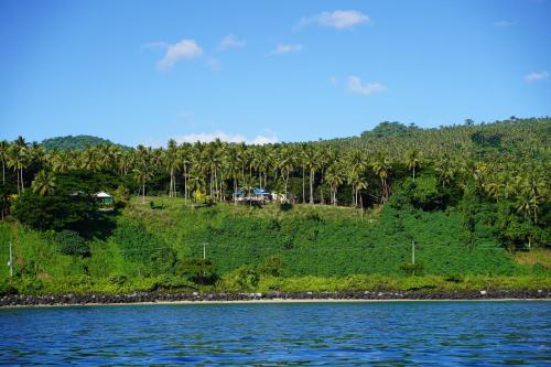a house on a hill next to a body of water at Lomani in Matei
