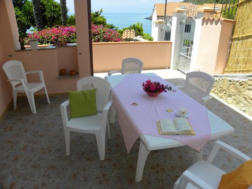 tavolo e sedie bianchi con tavolo e libri di 3 bedrooms apartement at Maratea 30 m away from the beach with sea view furnished balcony and wifi a Maratea
